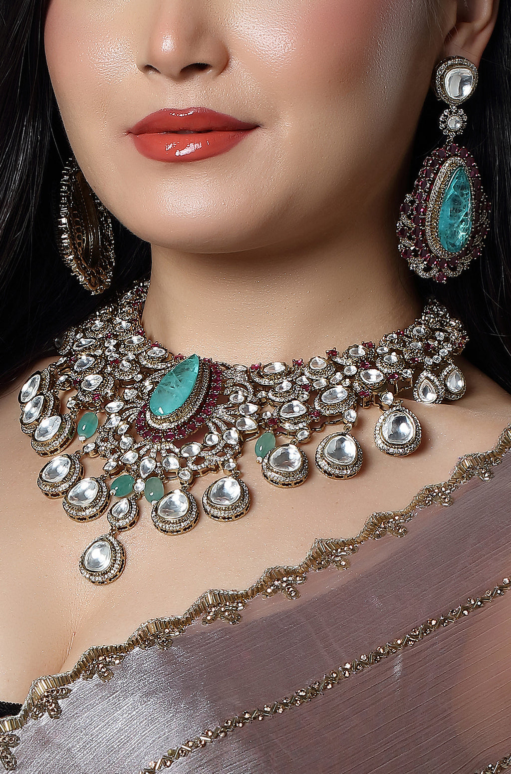 Close-up of a woman wearing a detailed necklace and earrings with turquoise stones.